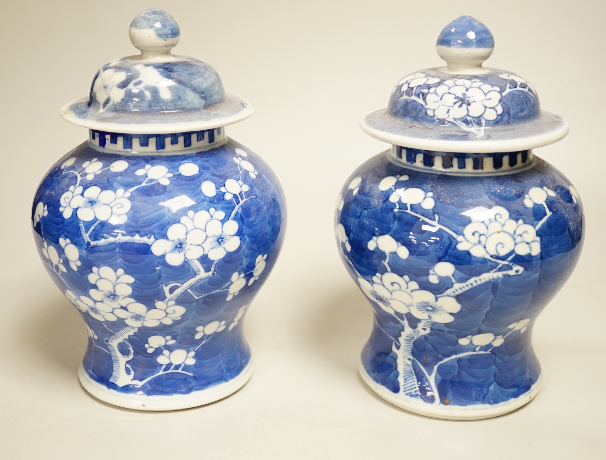 A pair of Chinese blue and white prunus pattern vases and covers, 21cm high
